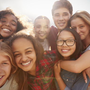 teenage-school-friends-smiling-to-camera-close-up-2024-10-21-13-33-48-utc teenage school friends smiling to camera close up